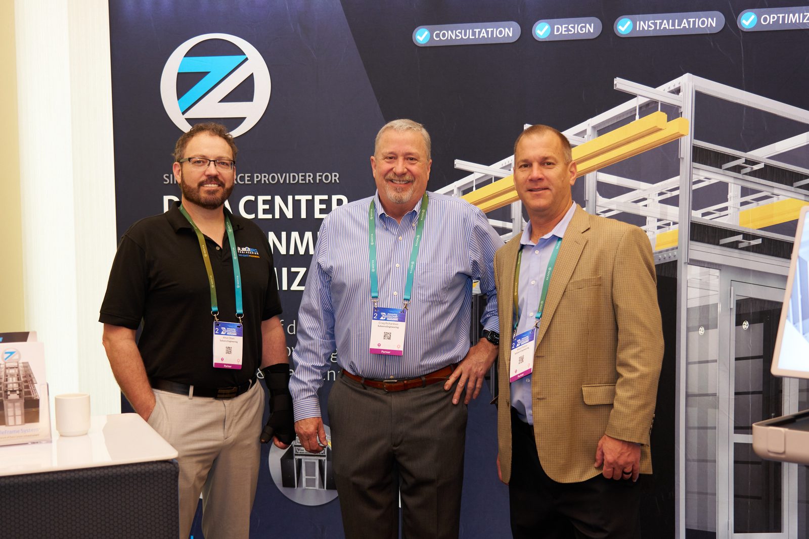 Exhibitor group photo in front of a trade show booth backdrop
