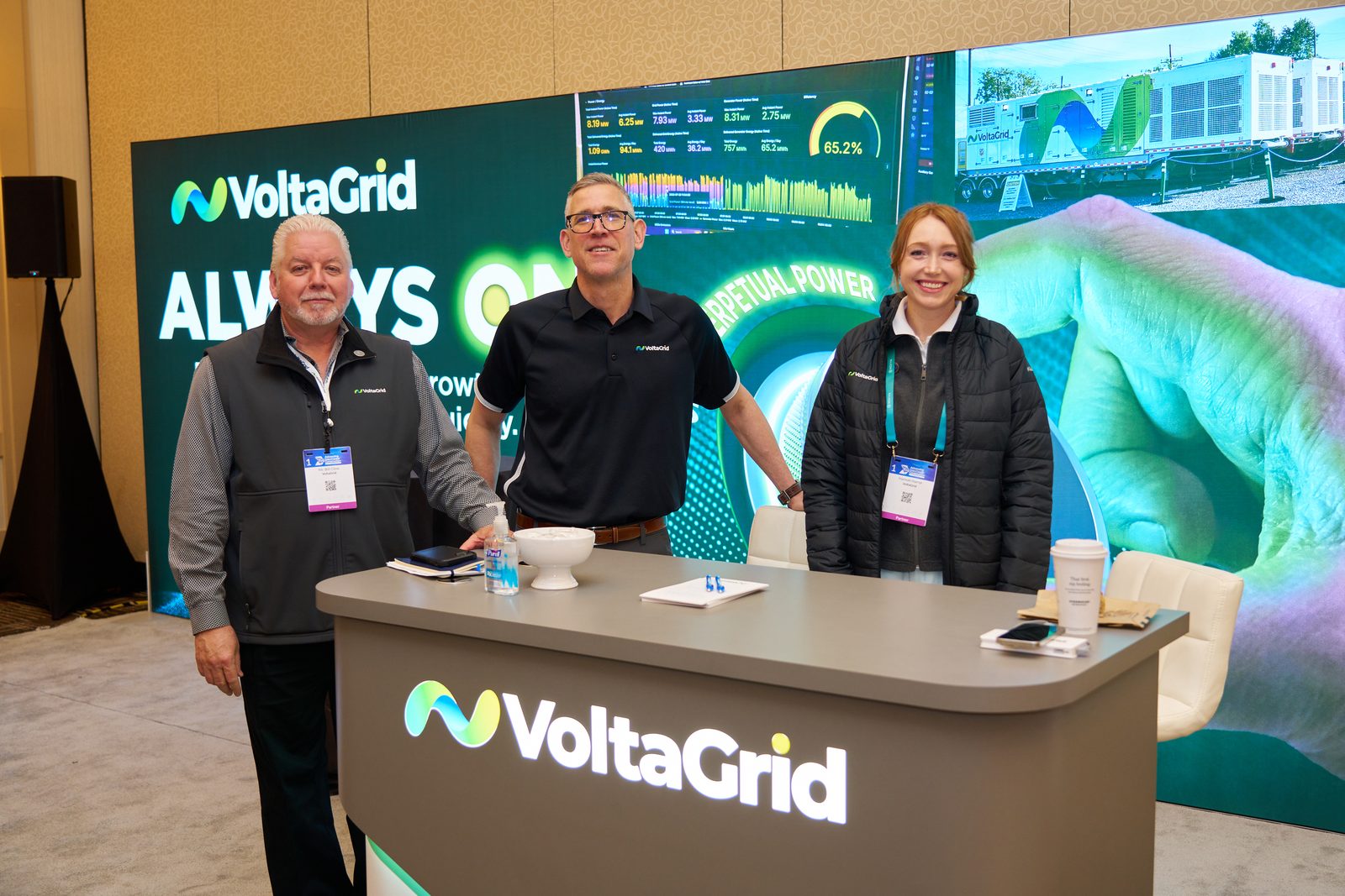 Exhibitor team posing at their booth counter during the trade show
