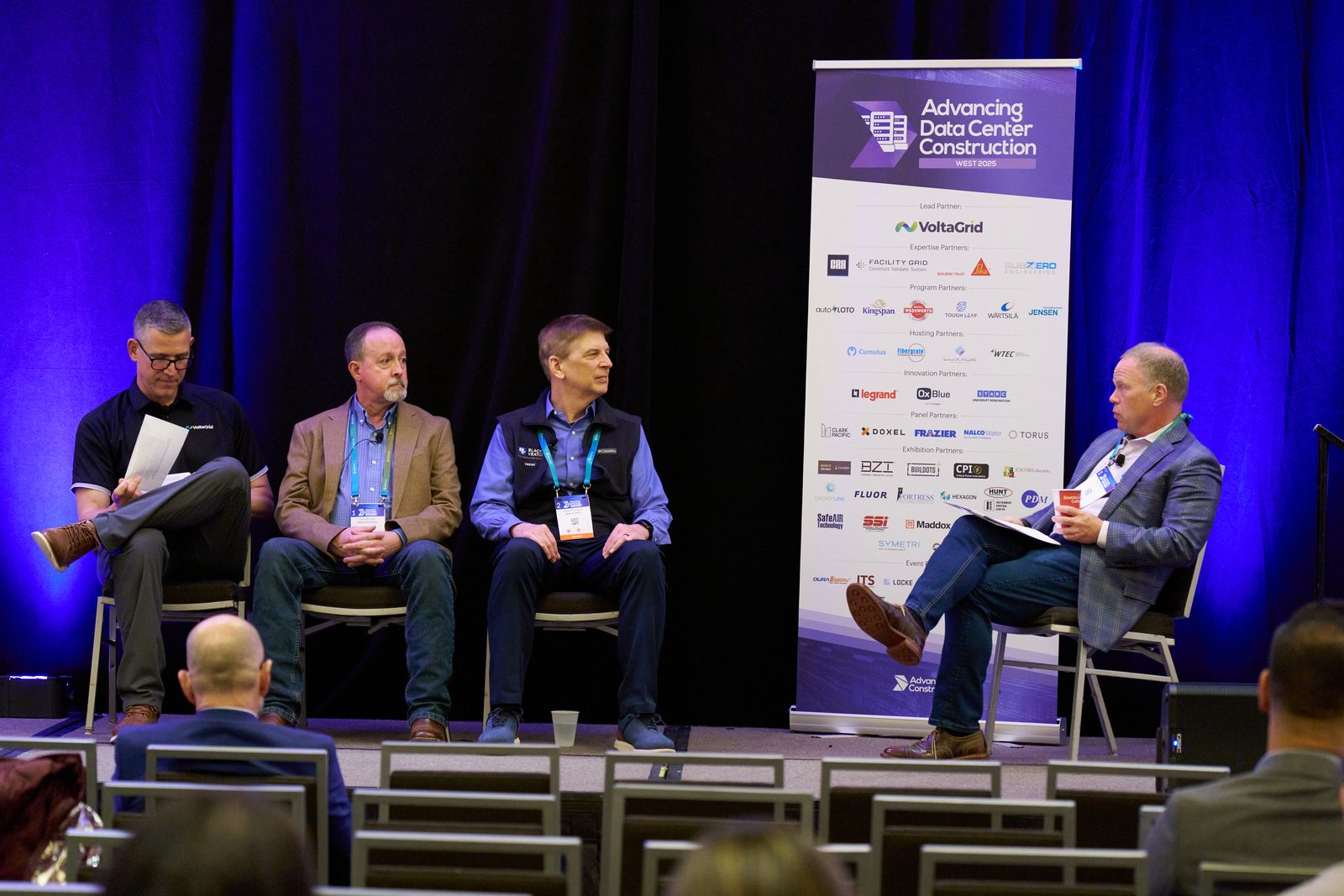 Panel discussion on stage beside the Advancing Data Center Construction West 2025 banner